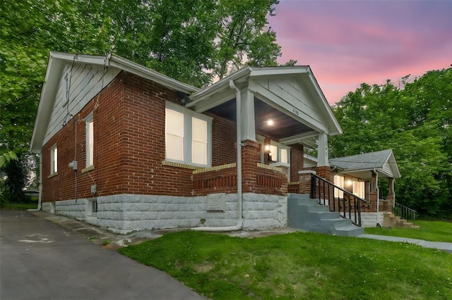 7348 Grand Dr, Pagedale, MO 63133 - view of front of house with brick siding, covered porch, and a lawn
