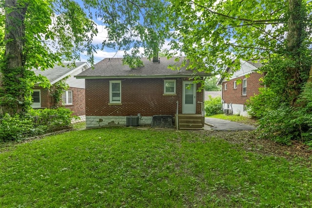 7348 Grand Dr, Pagedale, MO 63133 - rear view of house featuring brick siding, a yard, entry steps, central AC, and roof with shingles