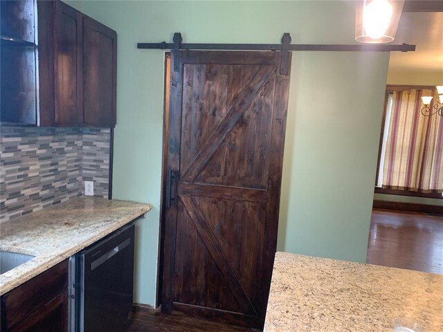 201 3rd St, Chaffee, MO 63740 - kitchen featuring dishwasher, a barn door, tasteful backsplash, dark wood-style flooring, and light stone counters