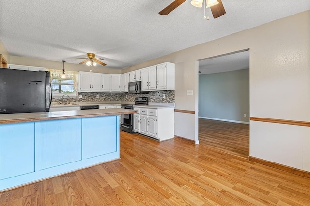 1111 Bluffview Dr, Desloge, MO 63628 - kitchen with black appliances, a ceiling fan, white cabinets, decorative backsplash, and a textured ceiling