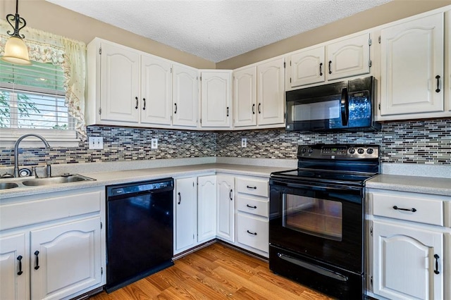 1111 Bluffview Dr, Desloge, MO 63628 - kitchen featuring black appliances, a sink, white cabinets, light countertops, and a textured ceiling