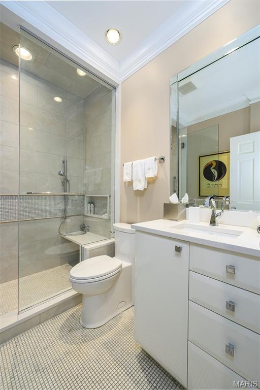 816 S Hanley Rd Unit 8C, Saint Louis, MO 63105 - full bath with ornamental molding, vanity, tiled shower, and tile patterned floors