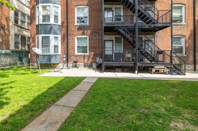 701 Limit Ave, University City, MO 63130 - back of property featuring a patio area, stairs, brick siding, and a lawn