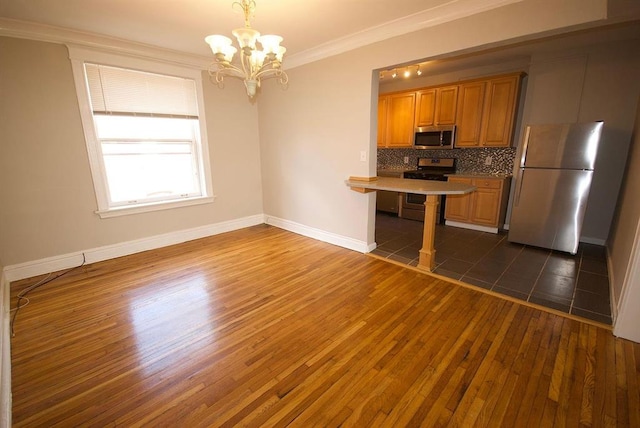 701 Limit Ave, University City, MO 63130 - kitchen with appliances with stainless steel finishes, dark wood-style floors, a chandelier, decorative backsplash, and baseboards