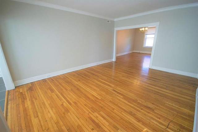 701 Limit Ave, University City, MO 63130 - empty room with a chandelier, light wood-style flooring, baseboards, and crown molding