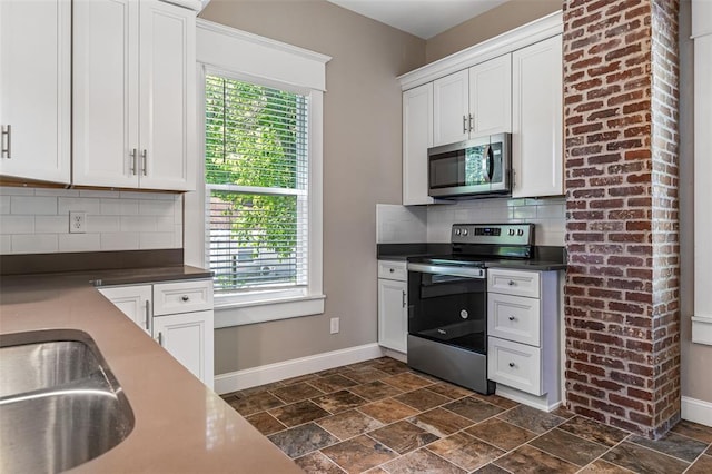 305 W 1st St, Farmington, MO 63640 - kitchen featuring appliances with stainless steel finishes, baseboards, decorative backsplash, and dark stone finish floors