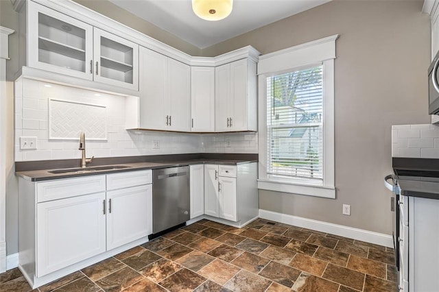 305 W 1st St, Farmington, MO 63640 - kitchen featuring dishwasher, dark countertops, a sink, baseboards, and tasteful backsplash