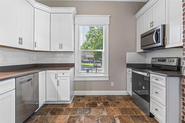 305 W 1st St, Farmington, MO 63640 - kitchen featuring appliances with stainless steel finishes, dark countertops, baseboards, dark stone finish flooring, and backsplash