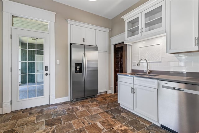 305 W 1st St, Farmington, MO 63640 - kitchen featuring stainless steel appliances, a sink, stone finish flooring, dark countertops, and baseboards