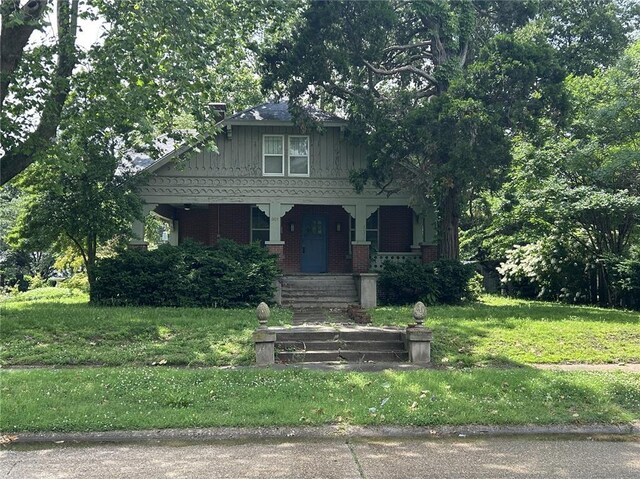 301 N Everett St, Kennett, MO 63857 - bungalow-style home featuring a porch, a front lawn, and brick siding