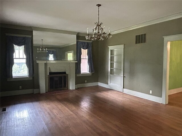 301 N Everett St, Kennett, MO 63857 - unfurnished living room featuring a chandelier, ornamental molding, baseboards, wood finished floors, and a brick fireplace