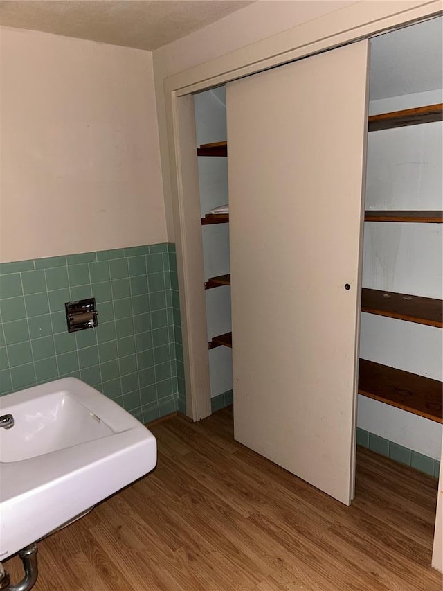 301 N Everett St, Kennett, MO 63857 - bathroom featuring tile walls, wood finished floors, and a wainscoted wall