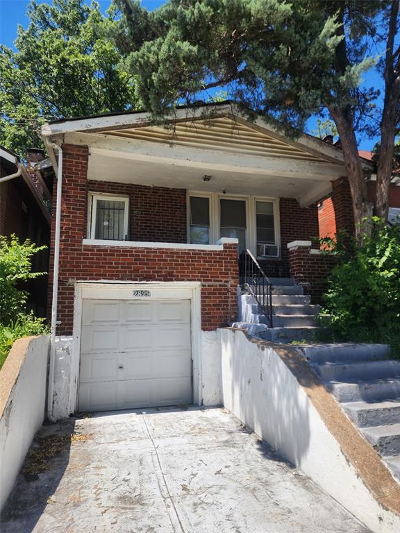 2829 Abner Pl, Saint Louis, MO 63120 - view of front of house with a garage, brick siding, concrete driveway, and cooling unit