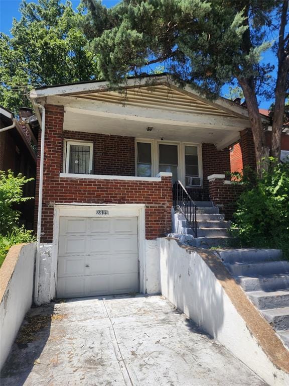 2829 Abner Pl, Saint Louis, MO 63120 - view of front of house with a garage, brick siding, concrete driveway, and cooling unit