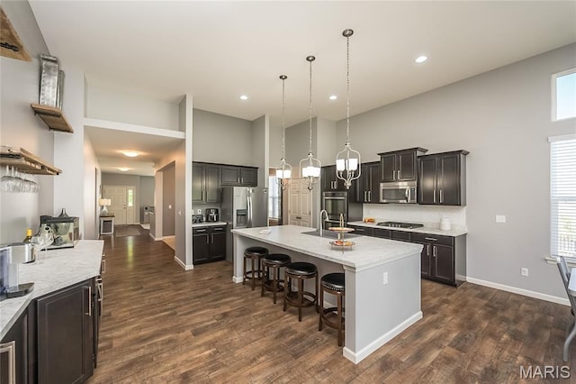 1510 Kennabrooke Ct, Saint Louis, MO 63146 - kitchen with high vaulted ceiling, stainless steel appliances, a breakfast bar area, tasteful backsplash, and dark wood-style floors