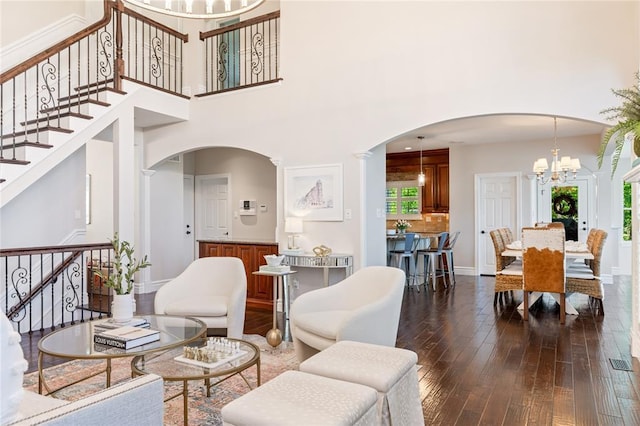5360 Tower Hill Ct, Weldon Spring, MO 63304 - living room with arched walkways, dark wood-type flooring, a chandelier, stairway, and a towering ceiling