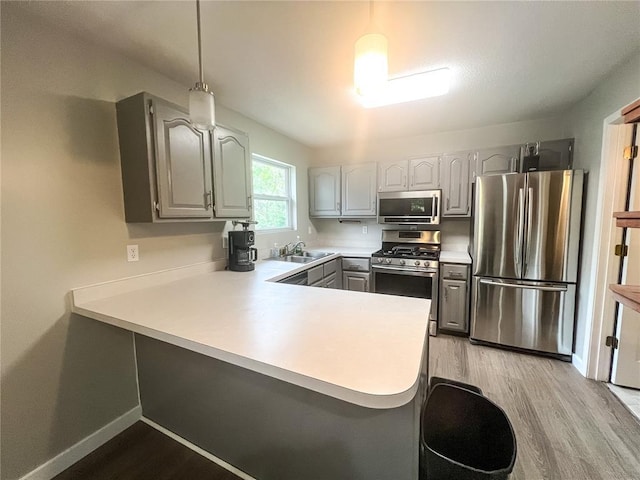 408 E Monroe St, Paris, MO 65275 - kitchen with stainless steel appliances, a peninsula, light wood finished floors, a sink, and gray cabinets