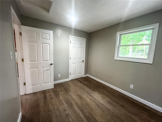 408 E Monroe St, Paris, MO 65275 - unfurnished bedroom featuring baseboards and dark wood finished floors