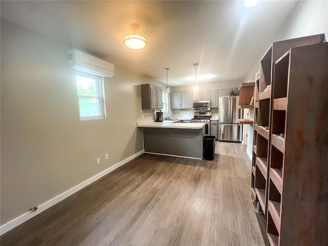 408 E Monroe St, Paris, MO 65275 - kitchen featuring appliances with stainless steel finishes, a peninsula, a wall unit AC, and dark wood-style flooring