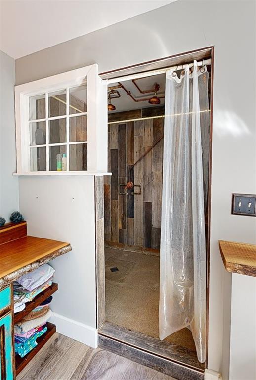 3828 Peters Ford Rd, Leslie, MO 63056 - bathroom with tiled shower, wood finished floors, and baseboards