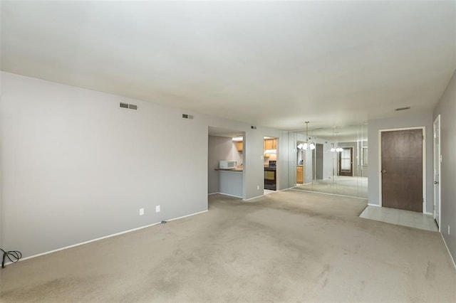 2 Fairways Cir Unit G, Saint Charles, MO 63303 - unfurnished living room featuring light carpet, baseboards, and a chandelier