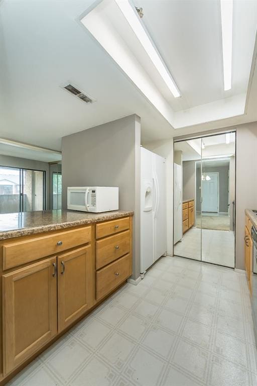 2 Fairways Cir Unit G, Saint Charles, MO 63303 - kitchen with white appliances, light flooring, and brown cabinetry