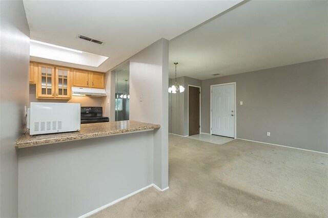 2 Fairways Cir Unit G, Saint Charles, MO 63303 - kitchen with white microwave, under cabinet range hood, range, a chandelier, and carpet floors