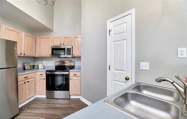 630 Homerun Dr Unit 12N, Ofallon, MO 63366 - kitchen with stainless steel appliances, light brown cabinetry, a sink, light countertops, and dark wood-style floors