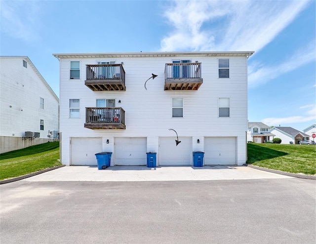 630 Homerun Dr Unit 12N, Ofallon, MO 63366 - rear view of house with a balcony, an attached garage, and a yard