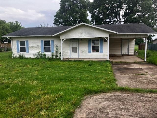 506 W Main St, Matthews, MO 63867 - ranch-style house featuring concrete driveway, a front lawn, a carport, and a porch