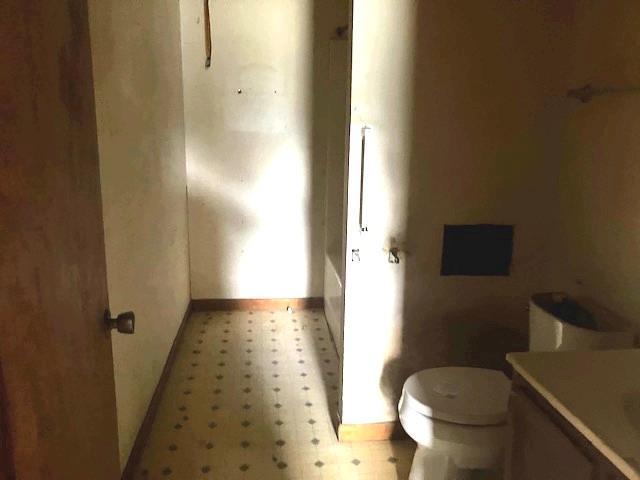 506 W Main St, Matthews, MO 63867 - bathroom featuring tile patterned floors, baseboards, toilet, and vanity