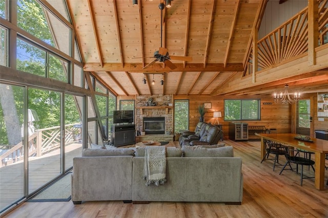 2349 Trautwein Dr, Innsbrook, MO 63390 - living area featuring high vaulted ceiling, wooden walls, a chandelier, a fireplace, and wood finished floors