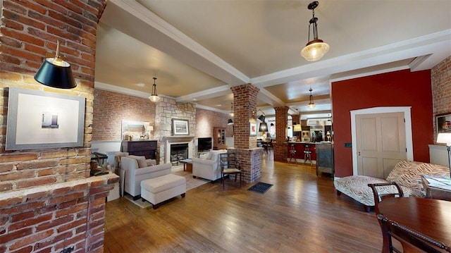 1107 N 2nd St, Saint Charles, MO 63301 - living area featuring ornate columns, a fireplace, wood finished floors, crown molding, and brick wall