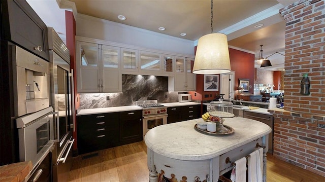 1107 N 2nd St, Saint Charles, MO 63301 - kitchen featuring stainless steel range, light wood finished floors, white microwave, pendant lighting, and dark cabinets