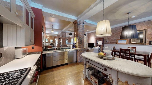1107 N 2nd St, Saint Charles, MO 63301 - kitchen with decorative columns, white microwave, light wood finished floors, light countertops, and brick wall