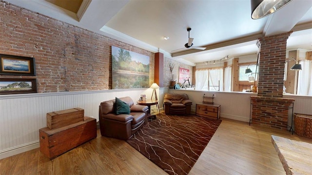 1107 N 2nd St, Saint Charles, MO 63301 - sitting room featuring ornate columns, wood finished floors, a ceiling fan, and a wainscoted wall