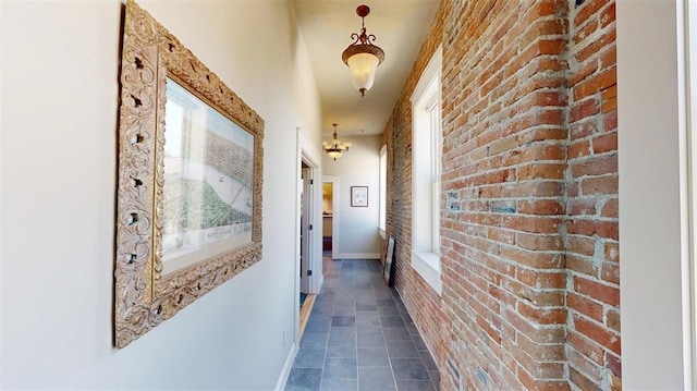 1107 N 2nd St, Saint Charles, MO 63301 - hall featuring brick wall, dark tile patterned flooring, and baseboards