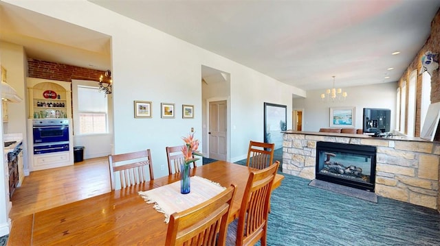 1107 N 2nd St, Saint Charles, MO 63301 - dining area featuring a chandelier, a stone fireplace, and wood finished floors