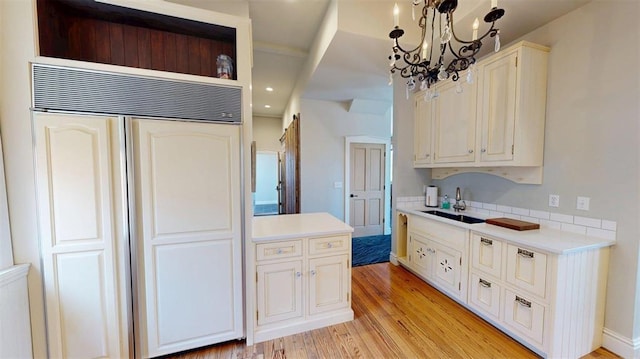 1107 N 2nd St, Saint Charles, MO 63301 - kitchen with a sink, built in fridge, light wood-style floors, a chandelier, and recessed lighting