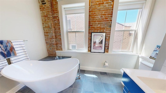 1107 N 2nd St, Saint Charles, MO 63301 - full bathroom with a soaking tub, a wainscoted wall, tile patterned floors, and a sink