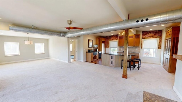 1107 N 2nd St, Saint Charles, MO 63301 - kitchen with light carpet, brown cabinets, plenty of natural light, and dark countertops
