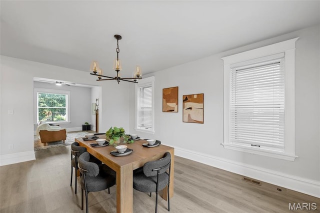 6014 Westminster Pl, Saint Louis, MO 63112 - dining space featuring a chandelier, light wood-style floors, and baseboards