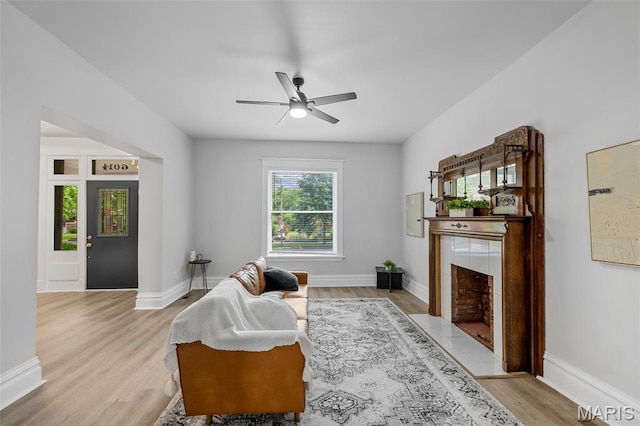 6014 Westminster Pl, Saint Louis, MO 63112 - living area with a tiled fireplace, ceiling fan, light wood-type flooring, and baseboards