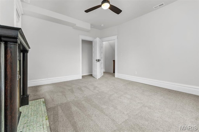 6014 Westminster Pl, Saint Louis, MO 63112 - unfurnished living room featuring a ceiling fan, carpet flooring, baseboards, and a wood stove