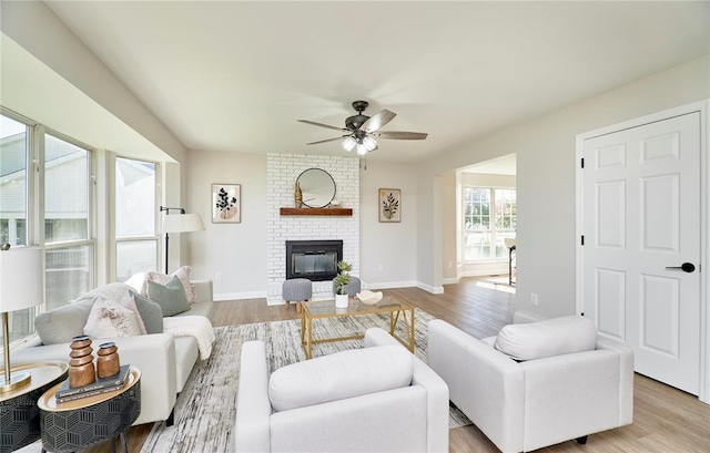 7219 Watsons Parish Dr, Ofallon, MO 63368 - living area with a ceiling fan, a brick fireplace, wood finished floors, and baseboards