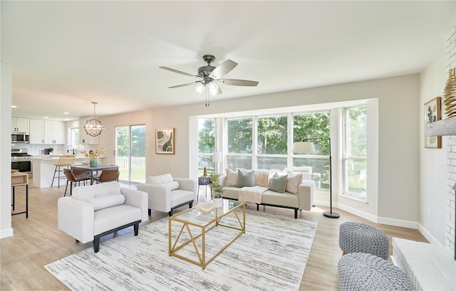 7219 Watsons Parish Dr, Ofallon, MO 63368 - living area with light wood-style floors, baseboards, a ceiling fan, a large fireplace, and recessed lighting