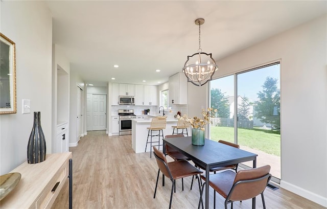7219 Watsons Parish Dr, Ofallon, MO 63368 - dining area with a chandelier, light wood-style floors, recessed lighting, and baseboards