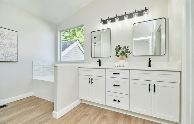 7219 Watsons Parish Dr, Ofallon, MO 63368 - full bath with vaulted ceiling, double vanity, wood finished floors, baseboards, and a tub