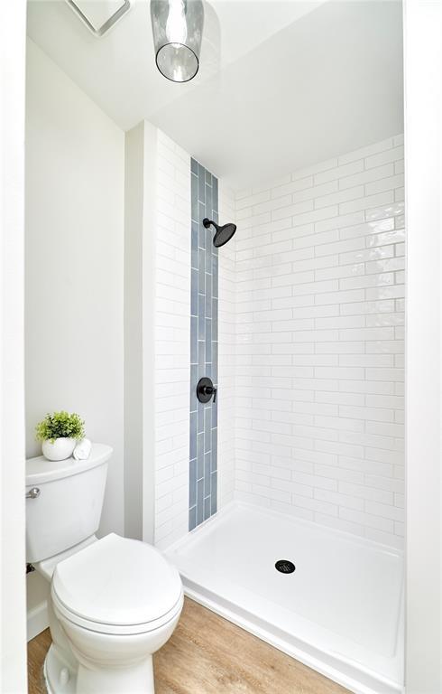 7219 Watsons Parish Dr, Ofallon, MO 63368 - bathroom with toilet, a tile shower, and wood finished floors