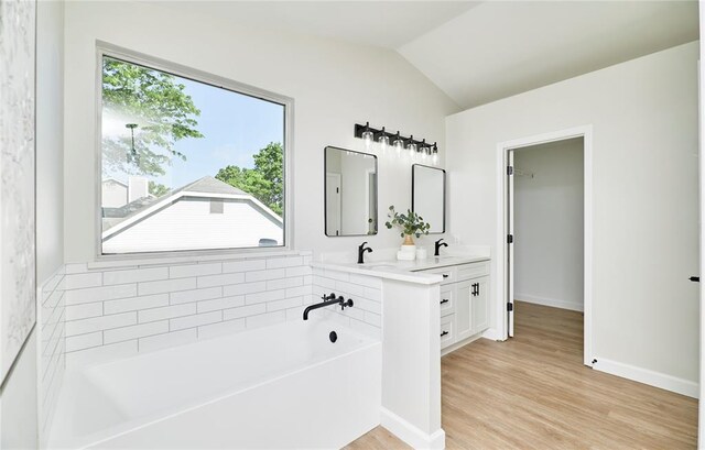7219 Watsons Parish Dr, Ofallon, MO 63368 - full bath featuring plenty of natural light, vaulted ceiling, double vanity, wood finished floors, and a garden tub